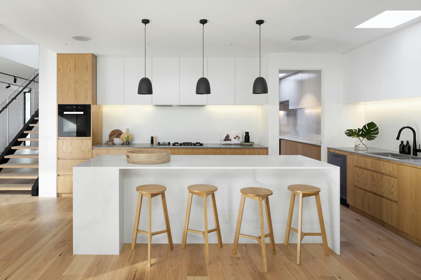 Modern kitchen with mixed wood-grain and white cabinets — reference photo used in the live pipeline run shown on this panel.